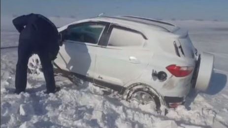 Полицейский откапывает машину