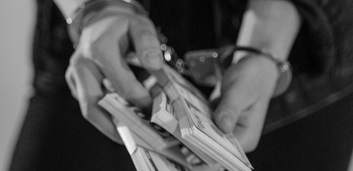 Женщина в наручниках и с деньгами