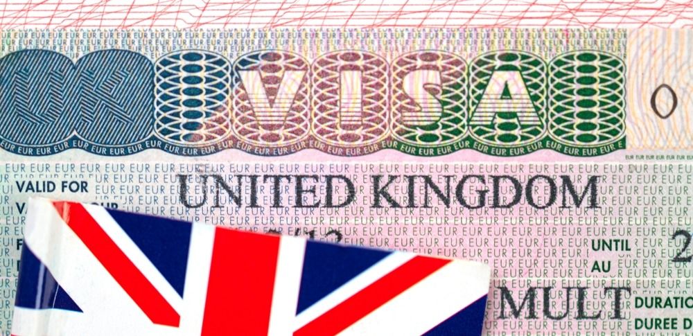 Крупный план визы Соединенного Королевства в паспорте с флагом Великобритании