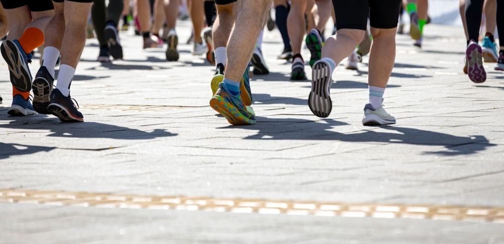 Большая группа бегунов, спортсмены бегут марафон 