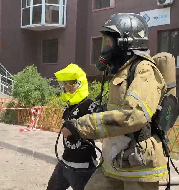 Пожарные выводят ребенка в специальной маске Пожарный, ребенок, спасательная маска